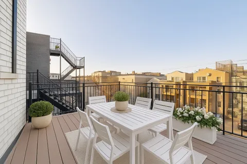 a view of a balcony with two chairs and a table