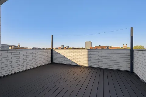 a view of a balcony with wooden floor and city view