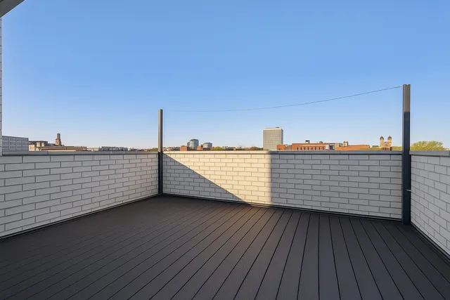 a view of a balcony with wooden floor and city view