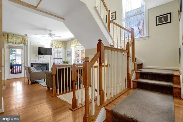 a living room with stainless steel appliances furniture a fireplace a flat screen tv and kitchen view