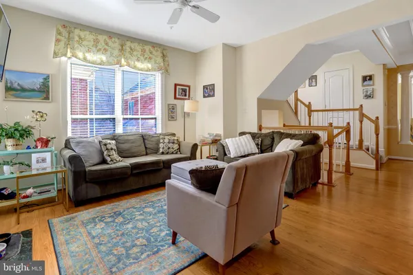 a kitchen with stainless steel appliances granite countertop a refrigerator a stove a sink a dining table and chairs with wooden floor