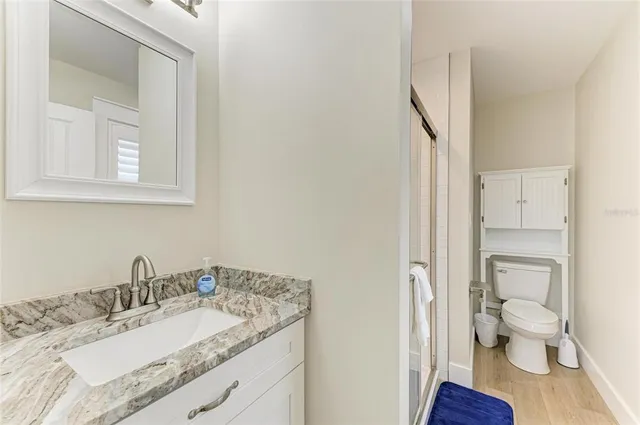 a bathroom with a granite countertop sink toilet and a mirror