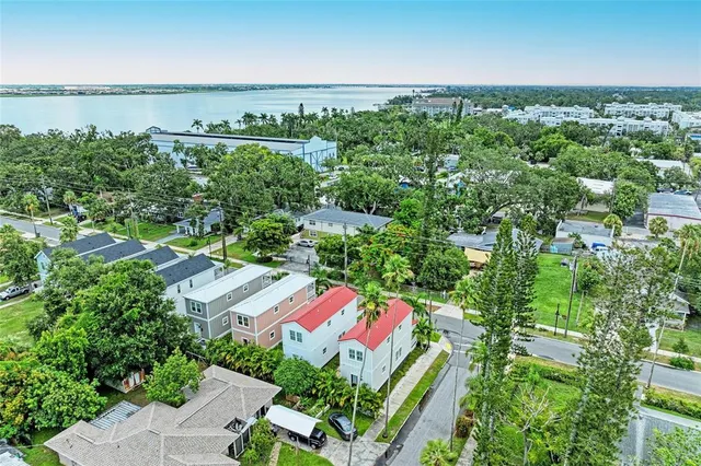 an aerial view of a city with lots of residential buildings ocean and mountain view in back