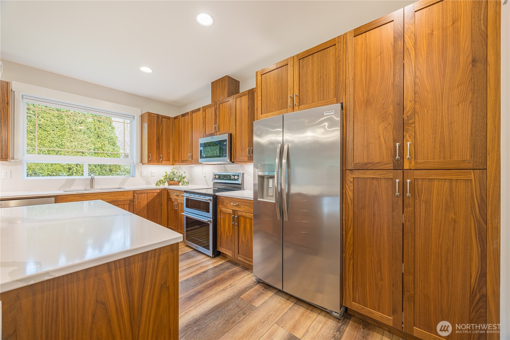 127 Sunrise View Avenue Sequim, WA 98382 - Photo 11 of 31 a kitchen with stainless steel appliances granite countertop a refrigerator a sink dishwasher and wooden cabinets with wooden floor