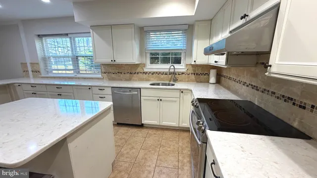 a kitchen with a sink a stove a microwave and cabinets