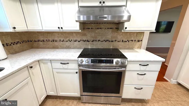a kitchen with a stove and white cabinets