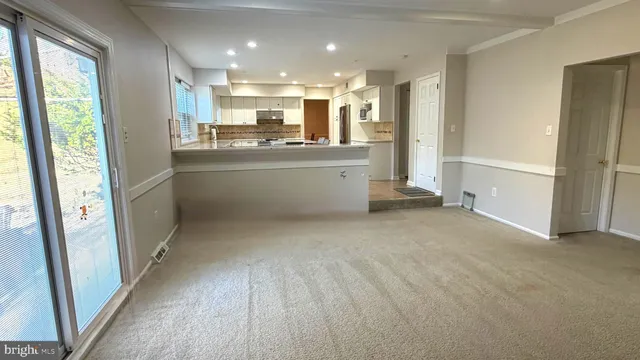 a view of a kitchen with refrigerator and windows