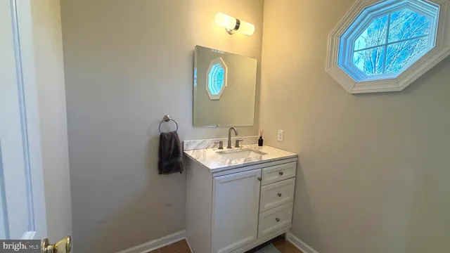 a bathroom with a granite countertop sink and mirror