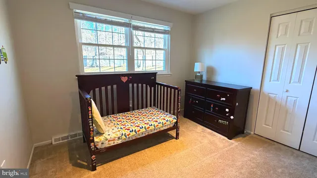 a bedroom with a bed window and a dresser