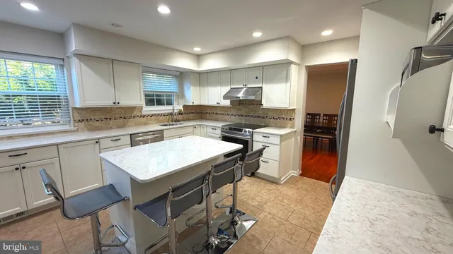 a kitchen with kitchen island a sink stove and refrigerator