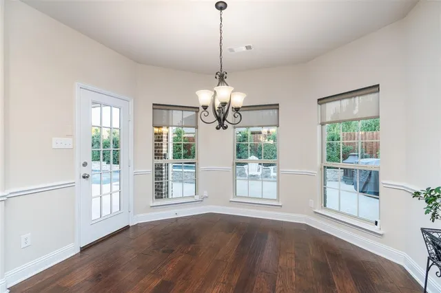 a kitchen with kitchen island a large counter top and a chandelier