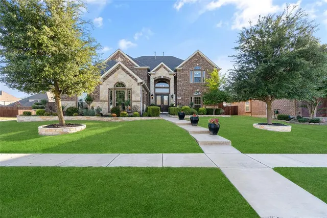 a front view of a house with a yard and trees