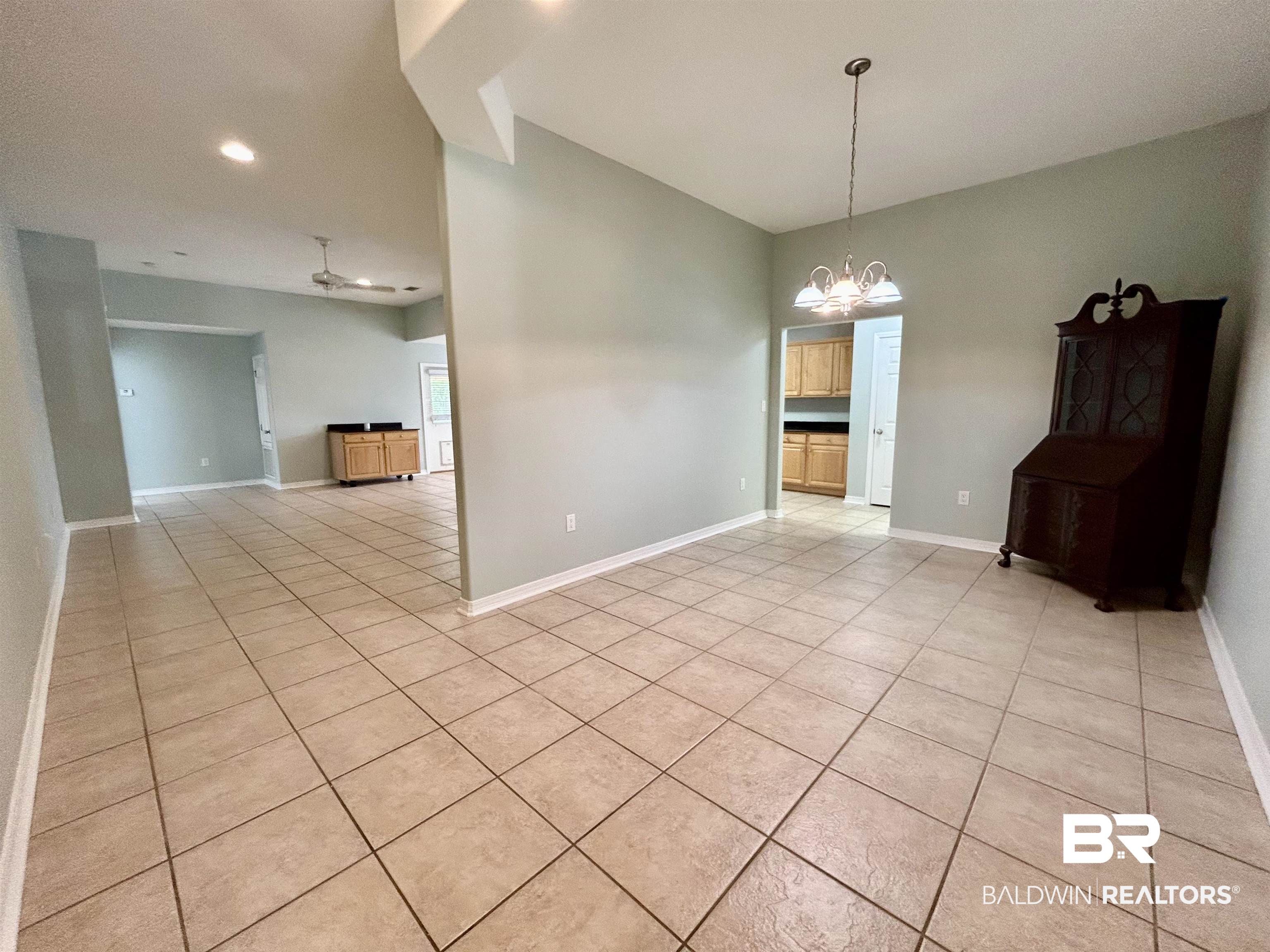 7198 Raintree Lane Gulf Shores, AL 36542 - Photo 8 of 33 Spacious room featuring tile flooring, light-toned wall paint, recessed lighting, and a prominent chandelier