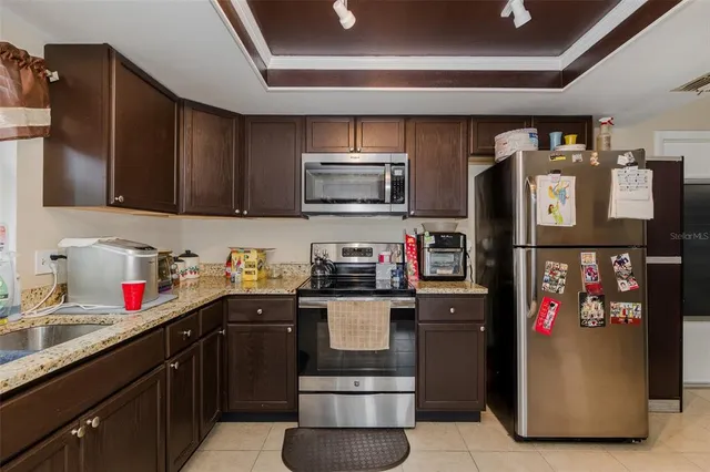 a kitchen with stainless steel appliances granite countertop a refrigerator and a sink