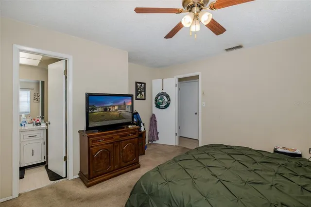 a bedroom with a bed and a flat tv screen on dresser