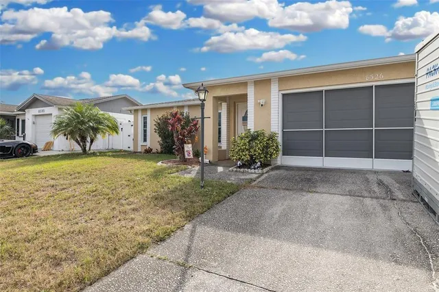 a view of a house with a yard and potted plants