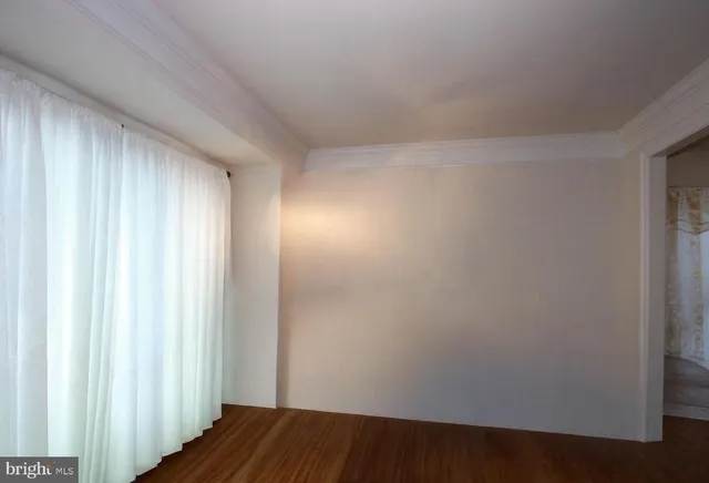 a view of a room with wooden floor and a window