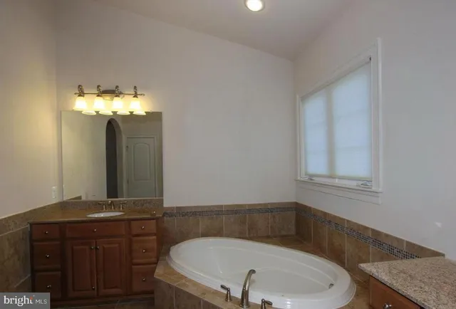 a bathroom with a granite countertop sink a toilet and a mirror