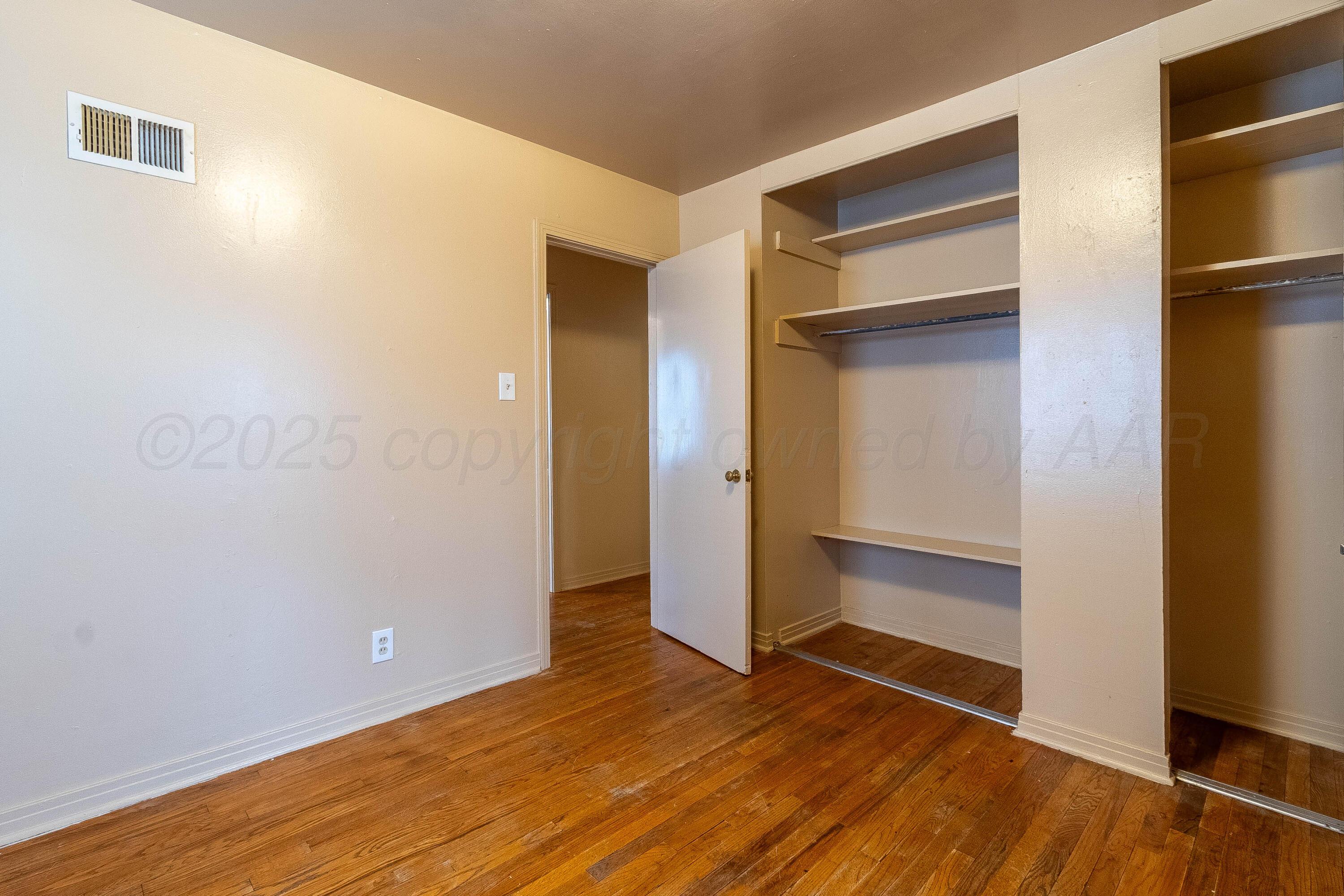 2414 Orange Street Amarillo, TX 79107 - Photo 11 of 16 a view of an empty room with wooden floor and closet