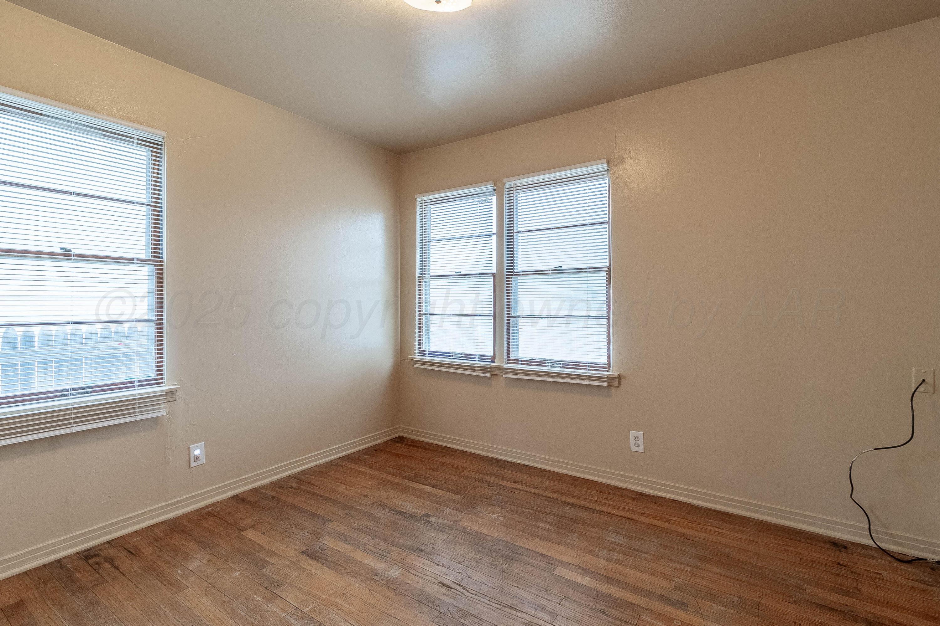 2414 Orange Street Amarillo, TX 79107 - Photo 12 of 16 an empty room with wooden floor and windows