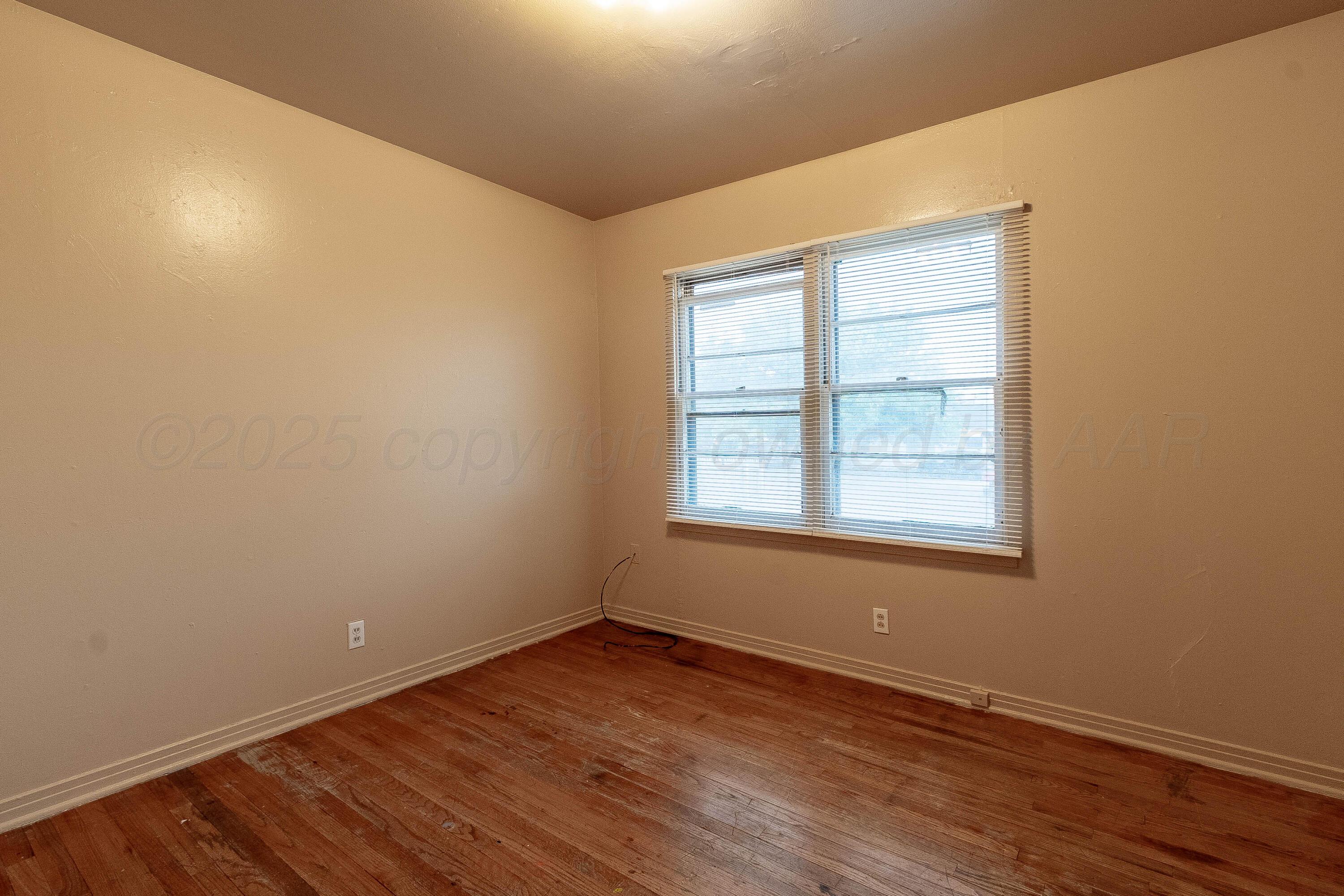 2414 Orange Street Amarillo, TX 79107 - Photo 14 of 16 an empty room with wooden floor and windows