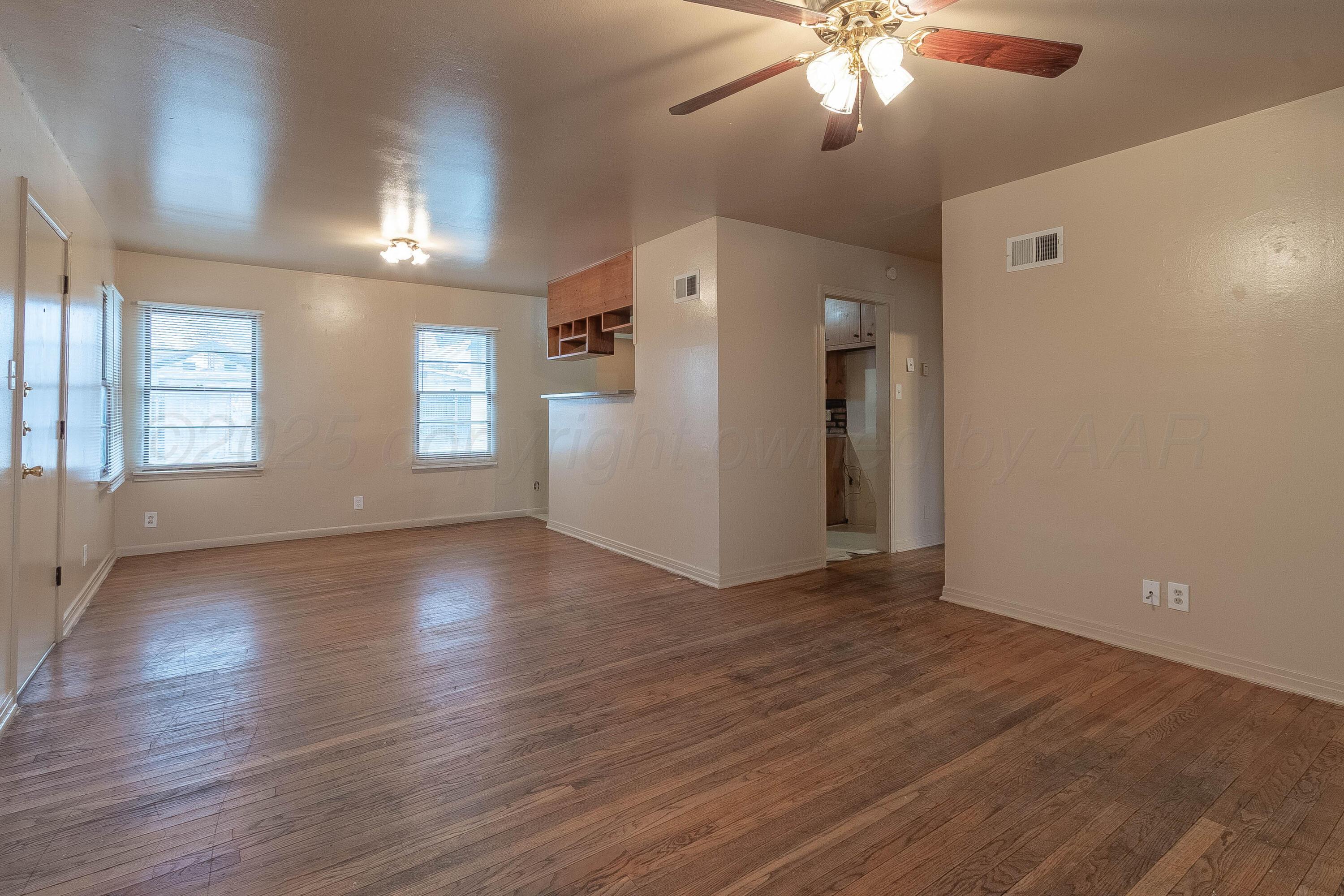 2414 Orange Street Amarillo, TX 79107 - Photo 2 of 16 a view of an empty room with window and wooden floor