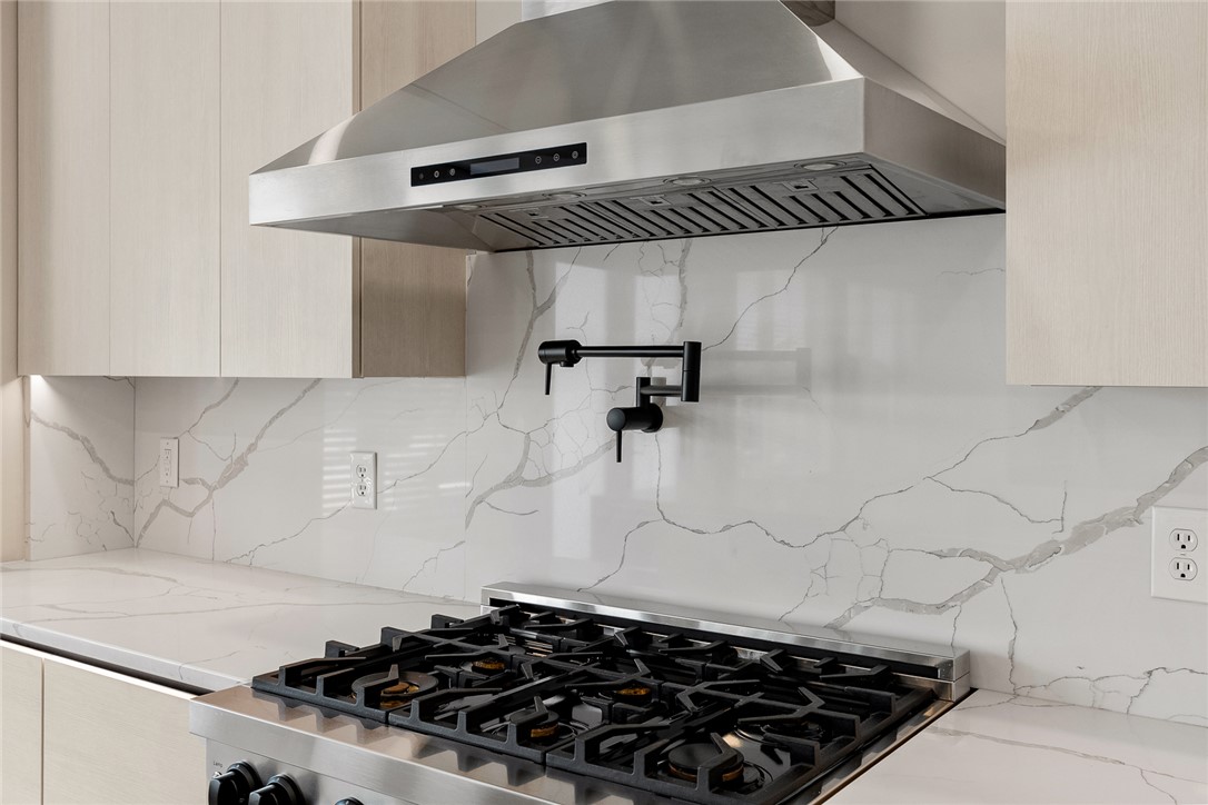 101 Casselberry Court Anderson, SC 29621 - Photo 16 of 48 This modern kitchen features a gas range with an exhaust fan, sleek cabinets, and a pot filler.