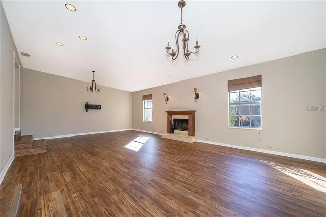 a view of empty room with wooden floor and fireplace