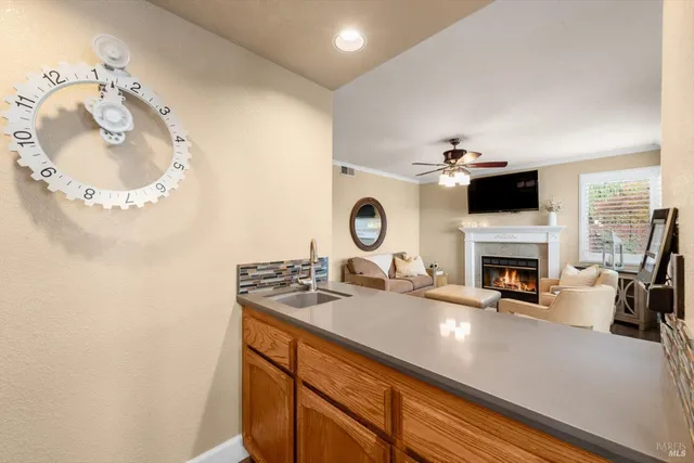 a living room with furniture a flat screen tv and kitchen view