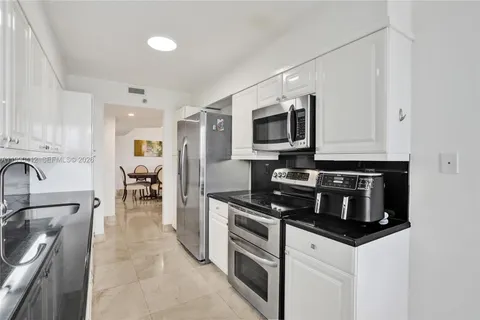 a kitchen with stainless steel appliances a stove microwave and sink