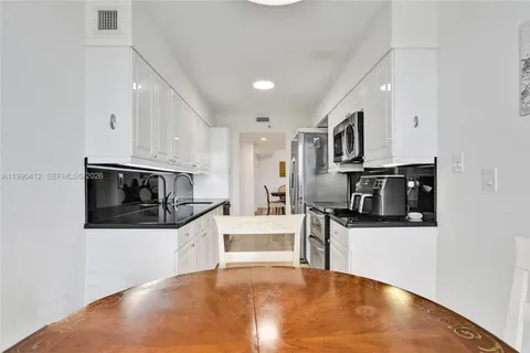 a kitchen with stainless steel appliances a stove a microwave and white cabinets