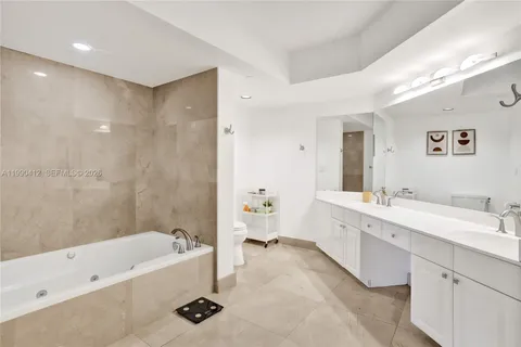 a bathroom with a tub a double vanity sink and mirror