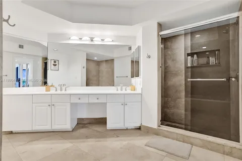 a bathroom with a sink vanity and shower