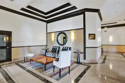 a living room with a table a rug and a window