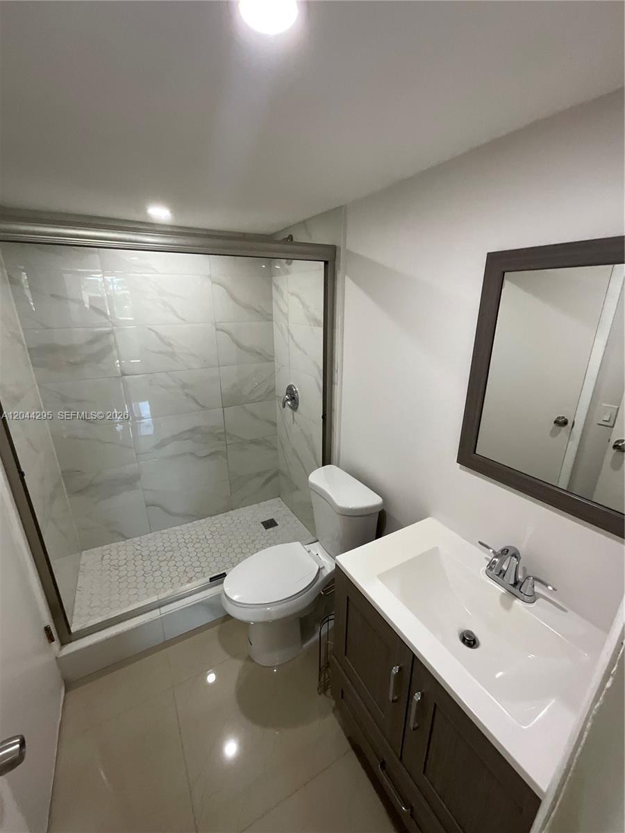 9441 Southwest 4th Street, Unit 214 Miami, FL 33174 - Photo 12 of 22 a bathroom with a double vanity sink toilet and mirror