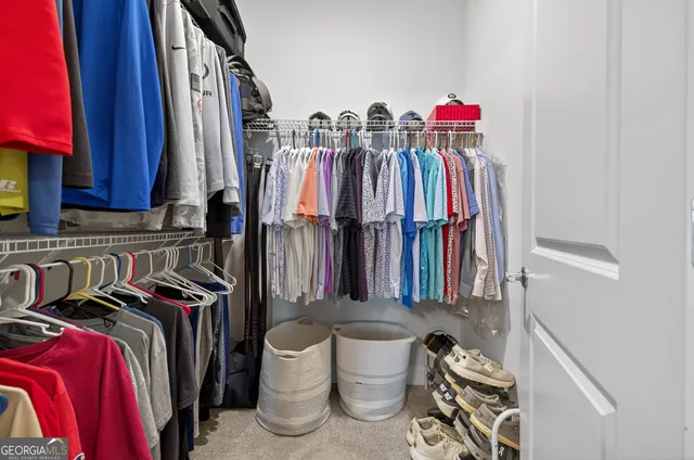 a view of walk in closet with clothes