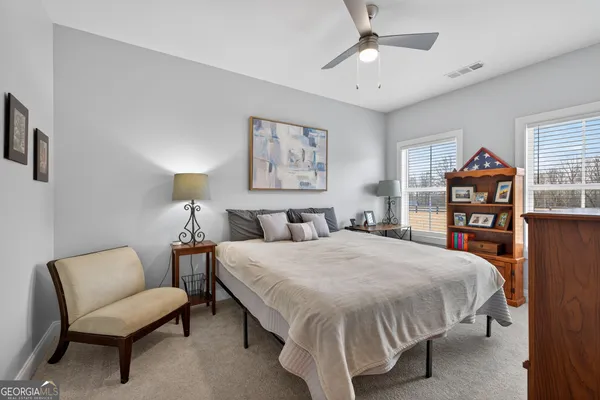 a bedroom with a bed a couch and a chandelier