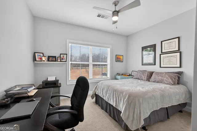 a bedroom with a bed window and a desk