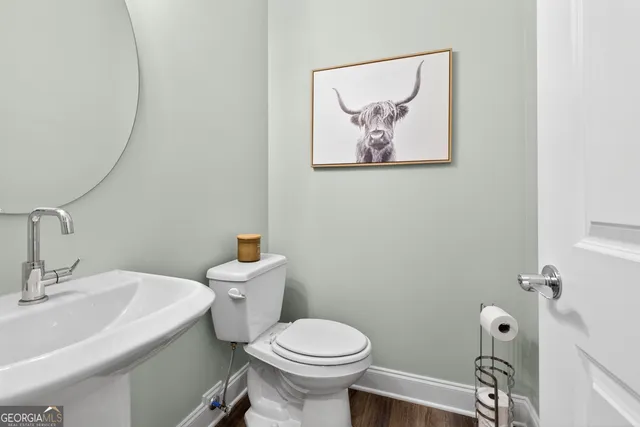 a bathroom with a toilet a sink and mirror