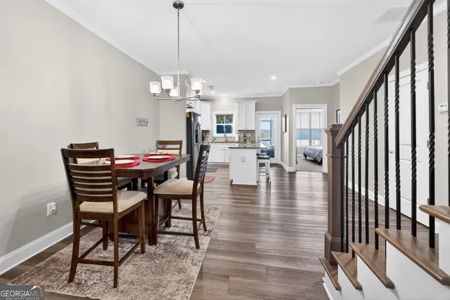 a view of a dining room and livingroom with furniture wooden floor a chandelier