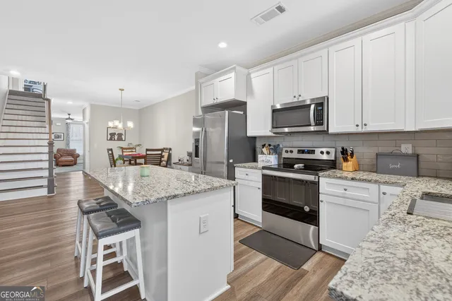 a kitchen with stainless steel appliances granite countertop a stove a sink and a microwave