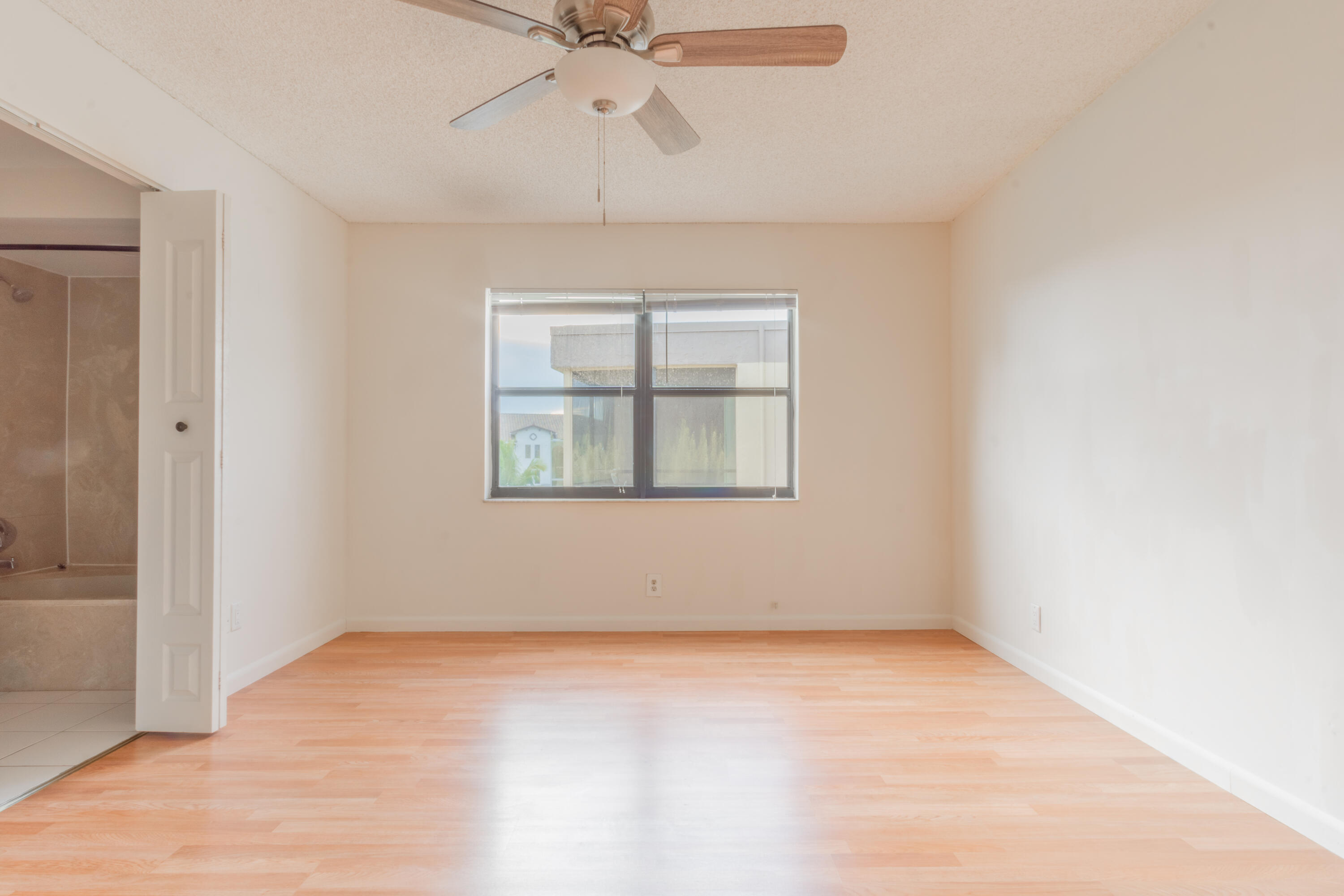 9355 Southwest 8th Street, Unit 406 Boca Raton, FL 33428 - Photo 7 of 22 an empty room with a window and ceiling fan