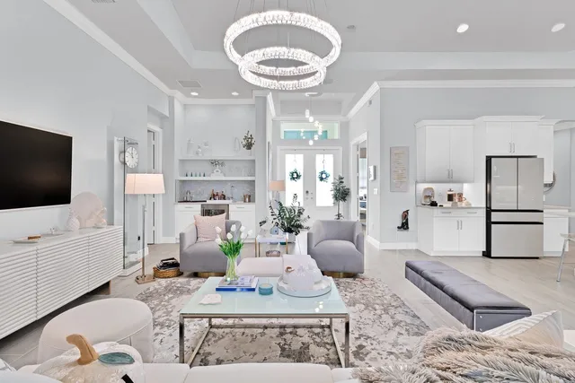 a living room with furniture a flat screen tv and kitchen view