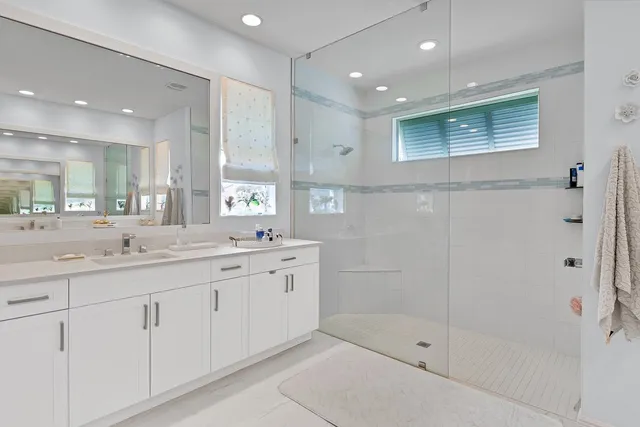a bathroom with a shower sink and mirror