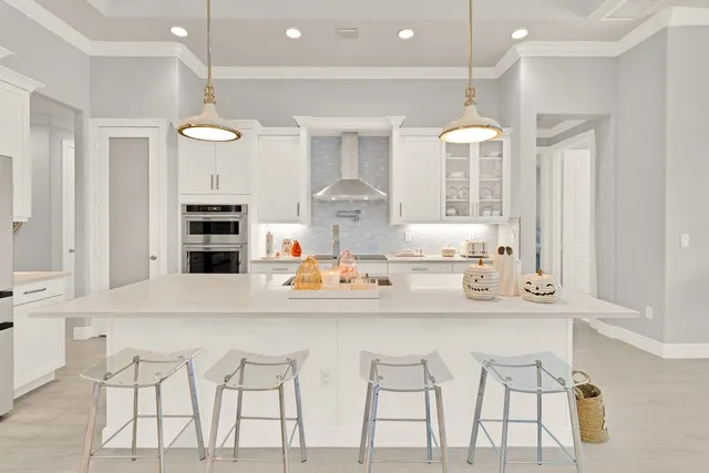 a kitchen with stainless steel appliances kitchen island granite countertop a stove and a white cabinets