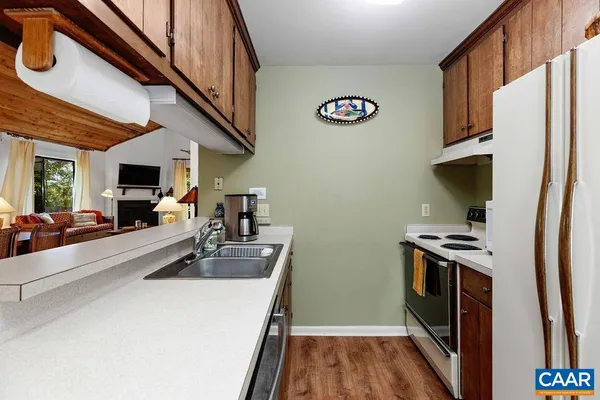 a kitchen that has a sink a stove and a refrigerator
