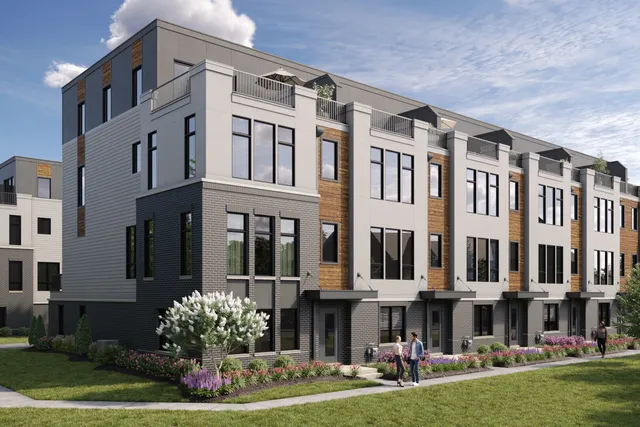 a front view of an apartment building with yard large tree and windows