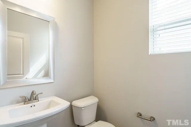 a bathroom with a sink mirror and toilet