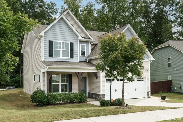 a front view of a house with a yard and potted plants