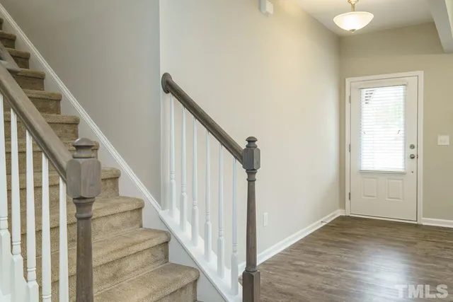 a view of staircase with wooden floor and white walls